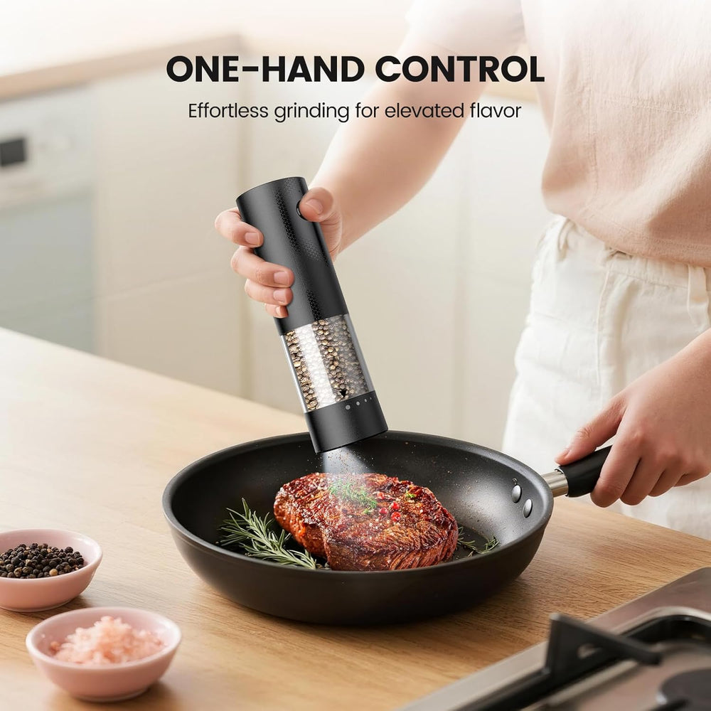 Electric salt and pepper grinder set with one-hand control for effortless grinding in a skillet.