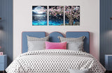 3 piece canvas wall art set featuring a pink tree and moon decor above a cozy bed in a modern bedroom.