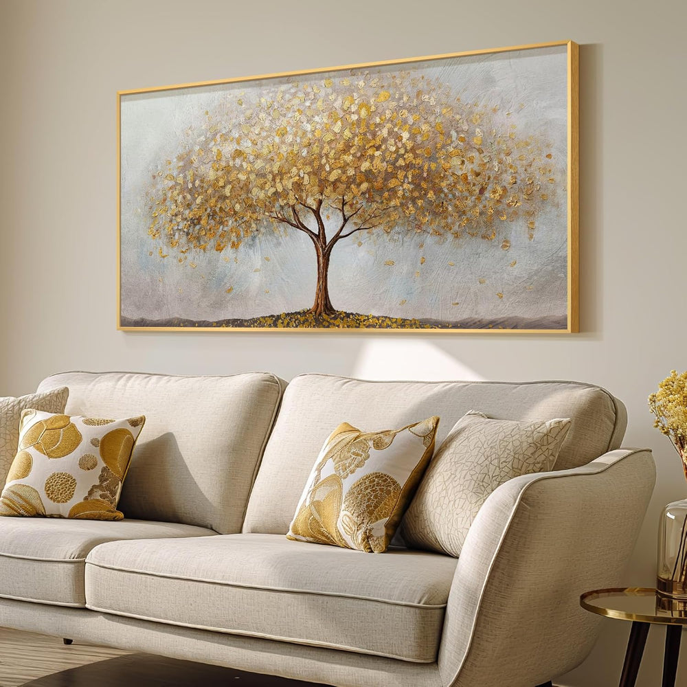 Large gold tree of life wall art displayed above a beige sofa with decorative pillows.