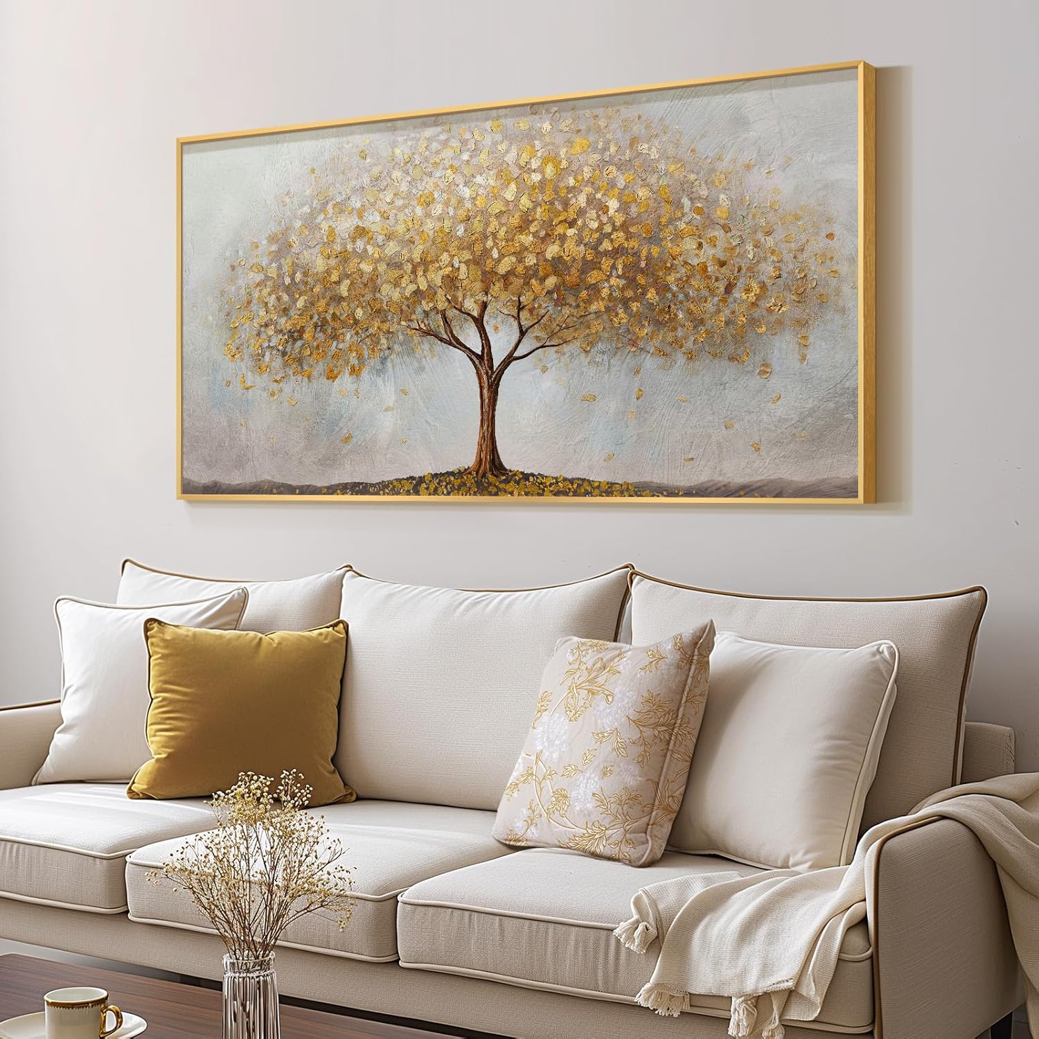 Large gold tree of life wall art framed canvas print above a cozy couch in a stylish living room.