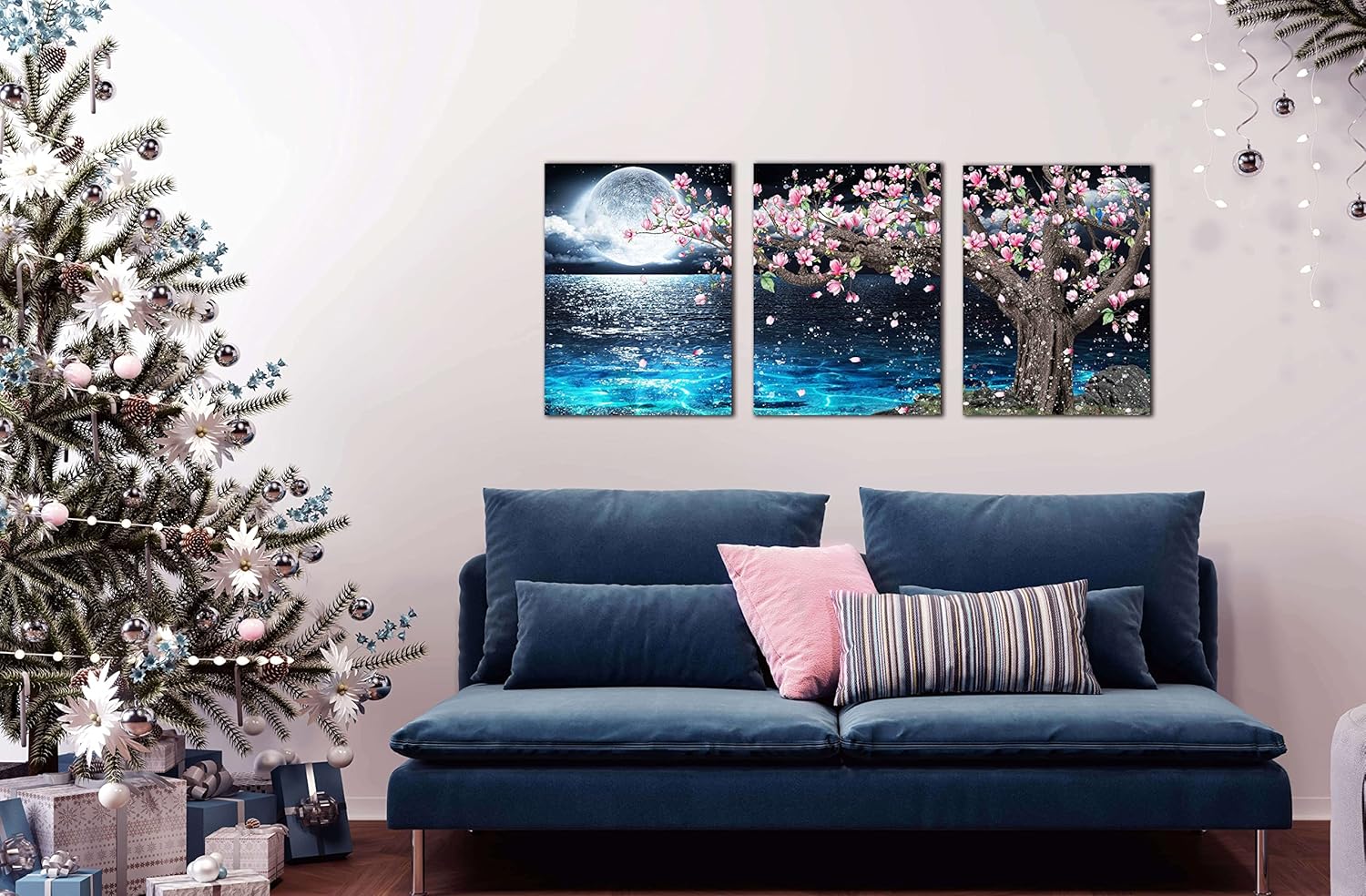 3 piece canvas wall art set showcasing a pink tree and moon decor above a blue sofa with a Christmas tree nearby.