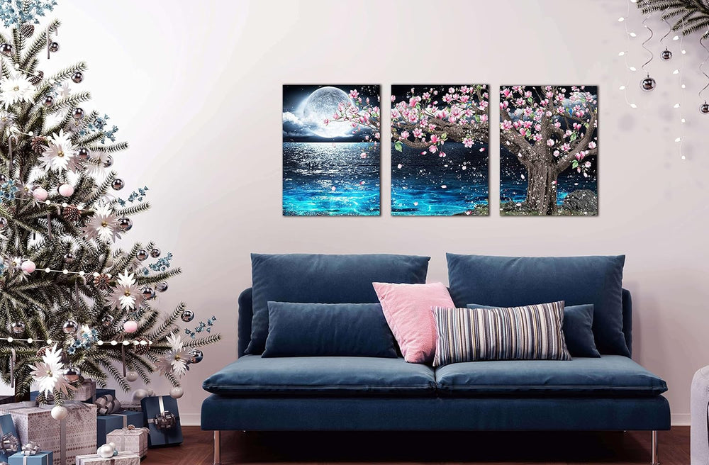 3 piece canvas wall art set showcasing a pink tree and moon decor above a blue sofa with a Christmas tree nearby.